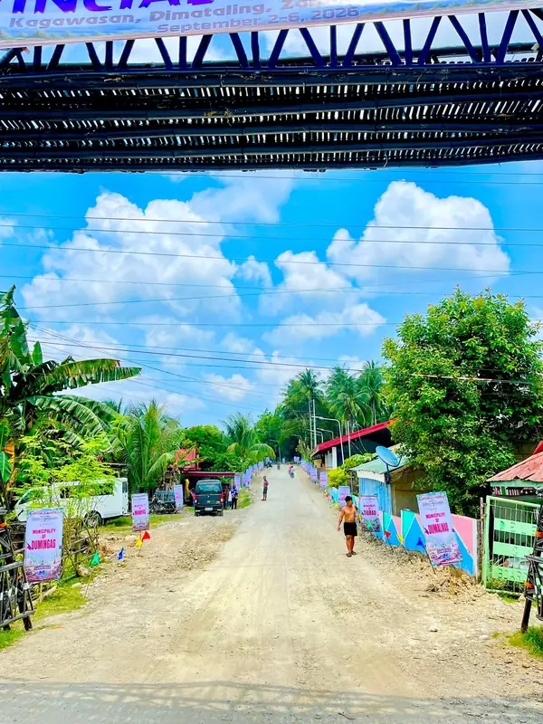 The dirt approach road to the jamboree site lined on both sides with coloured buntings and flags