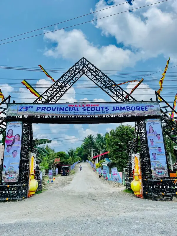 The jamboree welcome arch seen head-on from the approach road, flanked by tarpaulins of guest officials